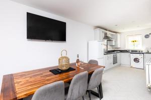 a kitchen and dining room with a wooden table and chairs at Coastal Retreat in Carmarthenshire in Llanelli