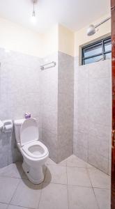 łazienka z toaletą i prysznicem w obiekcie Lux Suites Cavendish Square Apartments w mieście Syokimau