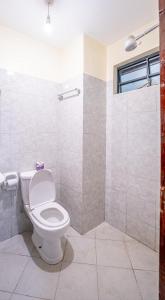 a bathroom with a toilet and a shower at Lux Suites Cavendish Square Apartments in Syokimau +17 photos