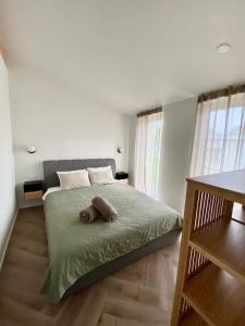 un dormitorio con una cama con un animal de peluche en Island House atostogų namai, en Gaylyunay