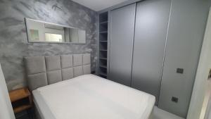a small bedroom with a bed and a cabinet at Silver DeLux Apartman in Balatonfüred