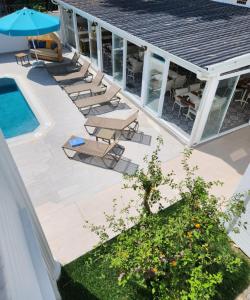 a patio with chairs and an umbrella next to a pool at Villa No 44 in Darıca