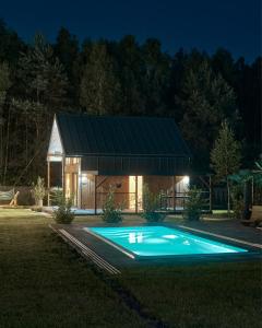 una casa con piscina por la noche en Osada Joniec, en Joniec