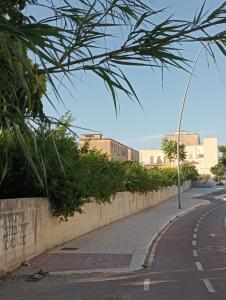 um passeio ao lado de uma parede e uma rua em LiMezzi House em Lecce