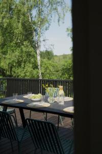 una mesa con sillas y un plato de comida en una terraza en Island House atostogų namai, en Gaylyunay