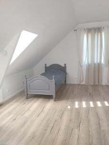 a bedroom with a bed and a wooden floor at Gîte Au Bord de la Baie de Somme in Quesnoy-le-Montant
