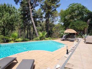 - une piscine avec 2 chaises et un parasol dans l'établissement UN OASIS EN PROVENCE, à Aubagne