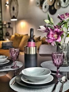 una mesa con platos y una botella de vino y flores en BNF Lounge en Varaždin
