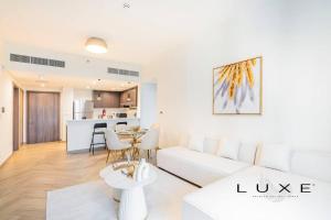 a living room with a white couch and a table at LUXE- 2BR With Sofabed Nordic Haven at 1 Residences Wasl 1 in Dubai