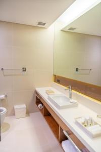 a bathroom with a sink and a mirror at The Bayleaf Cavite in General Trias