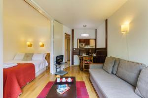 een woonkamer met een bed en een bank bij Chamonix Sud - Chamois Blanc 110 - Happy Rentals in Chamonix-Mont-Blanc