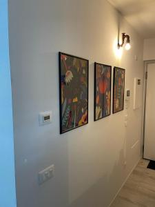 a hallway with four paintings on a wall at Green Life in Riva del Garda