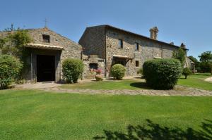 ein großes Steingebäude mit einem Rasenhof in der Unterkunft Agriturismo Buriano in Lubriano