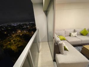 sala de estar con sofá y vistas a la ciudad en Departamento de estreno en Zona exclusiva de Surco, en Lima