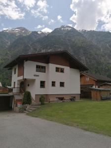 ein großes Haus mit Bergen im Hintergrund in der Unterkunft Ferienwohnung Pohl in Bach