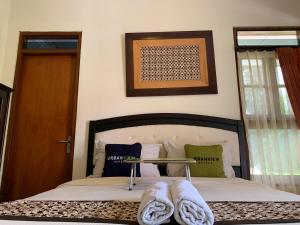 a bedroom with a bed with towels on it at Urbanview Sasono Putro Condoongcatur by RedDoorz in Yogyakarta