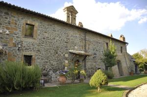 un antiguo edificio de piedra con un jardín delante de él en Agriturismo Buriano, en Lubriano