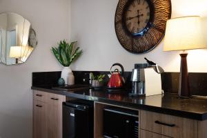 a kitchen with a counter with a clock on the wall at East Street Daylesford in Daylesford