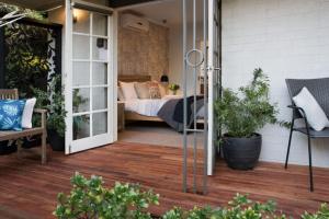 eine Terrasse mit einem Bett und einer Glasschiebetür in der Unterkunft East Street Daylesford in Daylesford