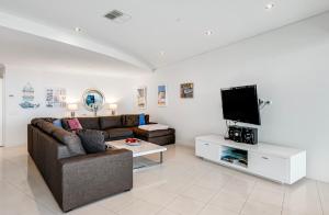 sala de estar con sofá y TV en Gallery 10 with views, pool and tennis court en Victor Harbor