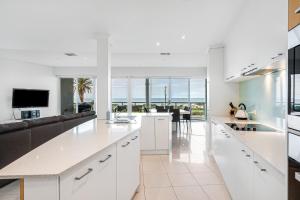 cocina abierta y sala de estar con encimeras blancas en Gallery 10 with views, pool and tennis court en Victor Harbor