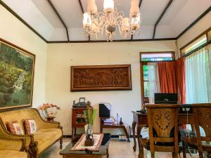 a living room with a couch and a chandelier at Urbanview Sasono Putro Condoongcatur by RedDoorz in Yogyakarta