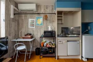 a small kitchen with a table and a refrigerator at イーストコート長崎 in Tokyo