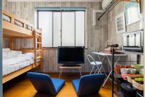 a bedroom with bunk beds with a desk and a television at イーストコート長崎 in Tokyo