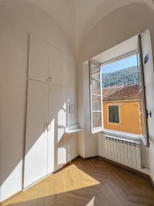 una stanza vuota con una grande finestra in un edificio di Alto Borgo Rooms a Finale Ligure