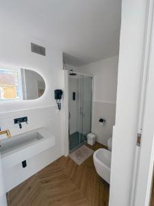 bagno bianco con lavandino e servizi igienici di Alto Borgo Rooms a Finale Ligure