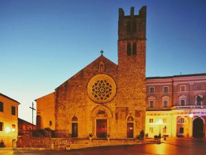 een groot bakstenen gebouw met een toren en een kerk bij L' Arco Rosa in Alatri
