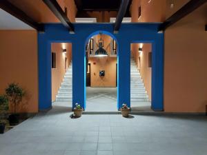 un couloir d'un immeuble avec colonnes bleues et escaliers dans l'établissement Melia Villas, à Ierissos