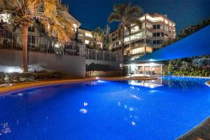 a large blue swimming pool in front of a building at Cairns Esplanade 2BR Waterfront Apartment Sleeps 6 in Cairns