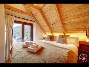 a bedroom with a large bed with towels on it at CASA CORILHA de Alma de Nieve in Salardú +32 photos