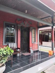 a front porch of a house with a black door at Hotel Lestari in Gilimanuk