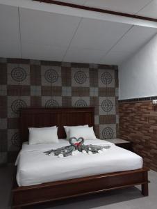 a bedroom with a large white bed with a large at Hotel Lestari in Gilimanuk