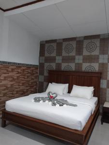 a bed with a stuffed animal on top of it at Hotel Lestari in Gilimanuk