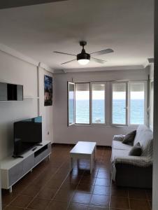 a living room with a couch and a flat screen tv at Apartamentos La Calilla Cabo de Gata in El Cabo de Gata