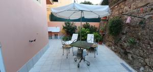 une terrasse avec une table et un parasol dans l'établissement Studio - Garden in the city, à Vintimille
