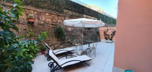 d'une terrasse avec des tables, des chaises et un parasol. dans l'établissement Studio - Garden in the city, à Vintimille