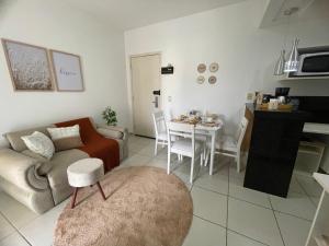 a living room with a couch and a table at Flat E311 - Aldeia das águas in Barra do Piraí