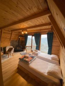 a bedroom with a large bed in a log cabin at Vaveyladağevleri in Çamlıhemşin