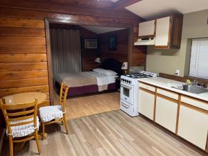 a kitchen with a bed and a kitchen with a stove at Merritt Lodge in Merritt