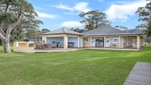 a house with a large yard in front of it at River Shack in Shoalhaven Heads