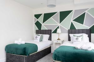 two beds in a bedroom with green and white at 20 Percent Off Monthly Stays - City Centre - Sky & Netflix in Hemel Hempstead