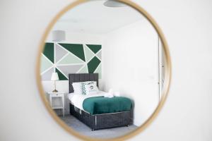 a bedroom with a bed and a mirror at Free Parking - City Centre - Sky & Netflix in Hemel Hempstead