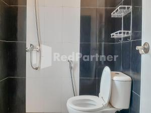 a bathroom with a toilet and a basketball hoop on the wall at Syariah Safar Guest House Mitra RedDoorz in Cijoho