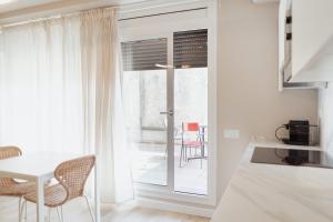 cocina con mesa, sillas y ventana en LA CASA del TOMÀS en Pobla de Segur