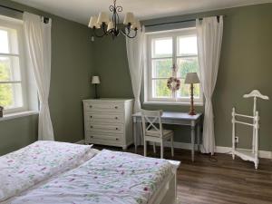 1 dormitorio con cama, escritorio y ventana en Apartmán Nad Modravou en Modrava