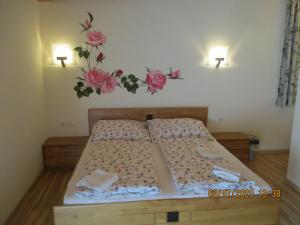 a bedroom with two beds with flowers on the wall at Gästehaus zur schönen Aussicht in Spitz